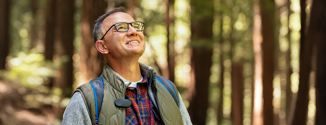 Image of middle-aged man in the woods and looking upward